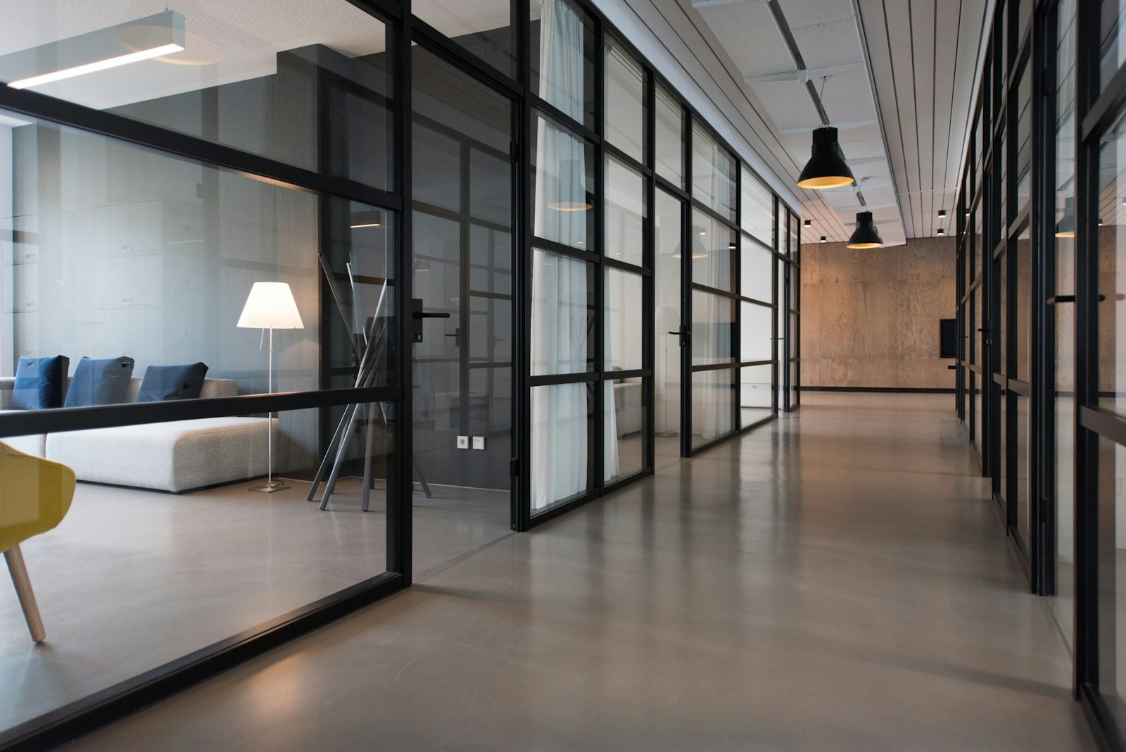 Glass-walled enterprise office where AI agents operate under defined permissions and oversight